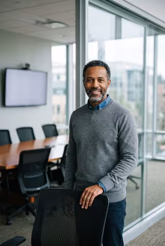 Research fellow portrait, glass-walled conference room — Person `person_portrait`.